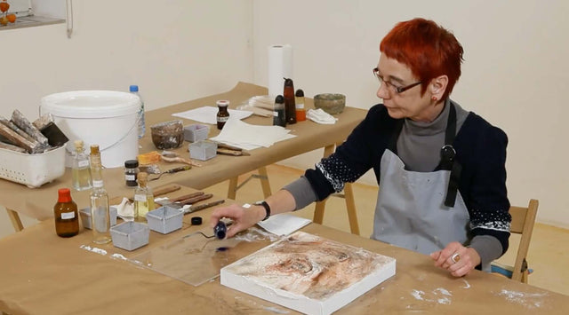 Künstlerin arbeitet mit Pigmenten an Strukturflächen im Kurs Fluss strukturierter Farbintensität.